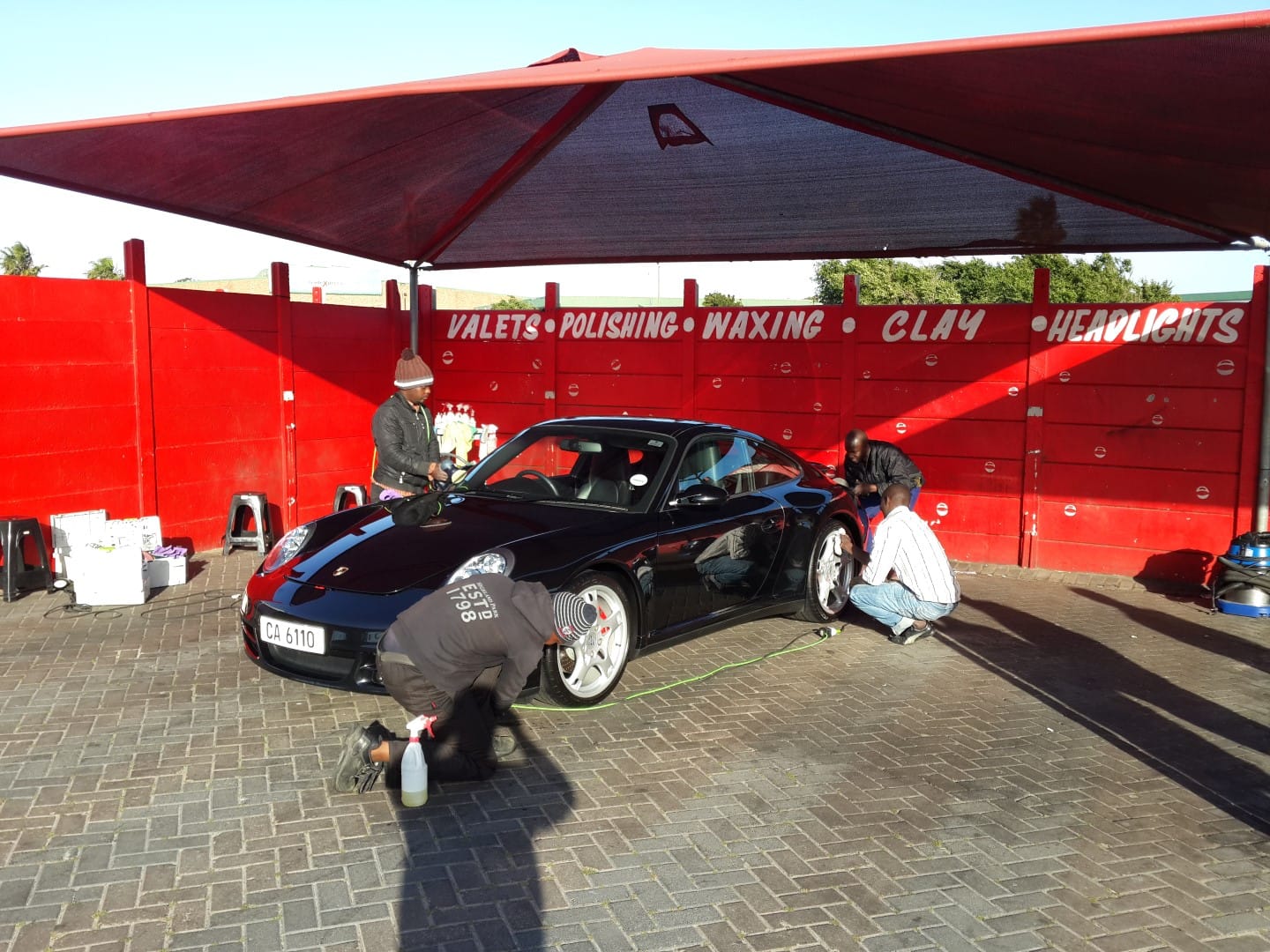 Team work makes the dream work - photo of the team correcting and detailing the Porsche
